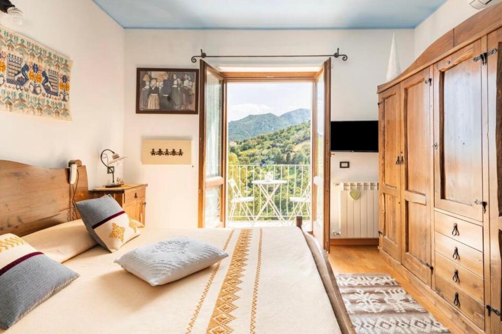 - une chambre avec un lit et une grande fenêtre dans l'établissement B&B Su Biancu - Sardinian Experience, à Urzulei