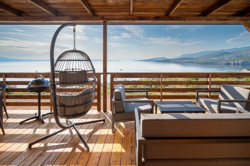 a porch with a hammock and a view of the water at Luxury Mobile home Zuzu Klenovica in Klenovica