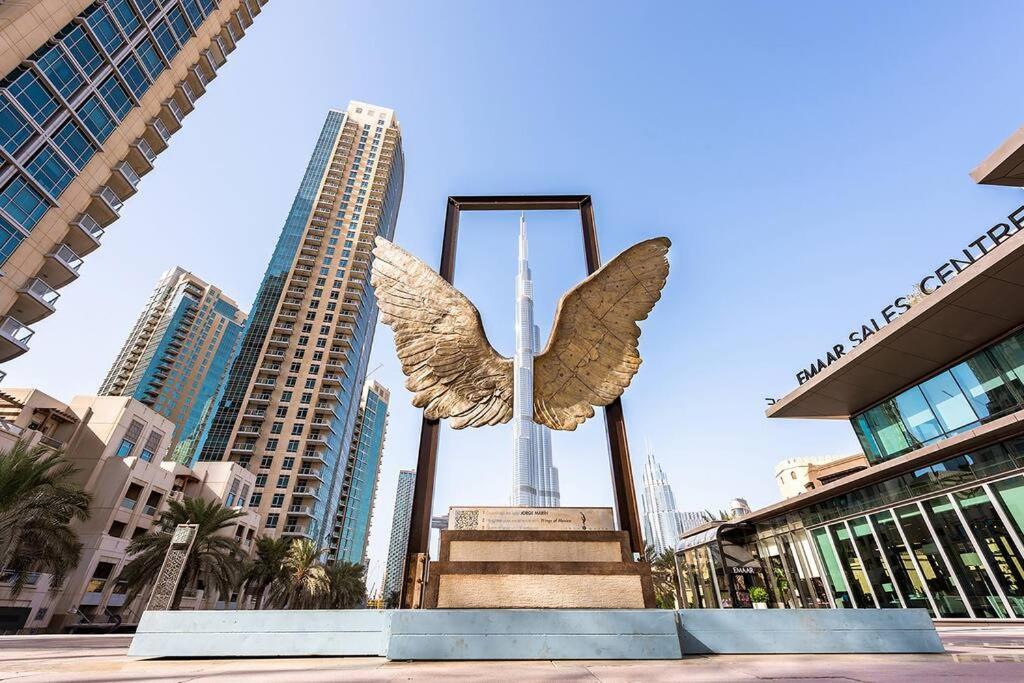 a statue of an angel with the city in the background at Lux Burj views -Boulevard -Prime Location Downtown DUBAI in Dubai