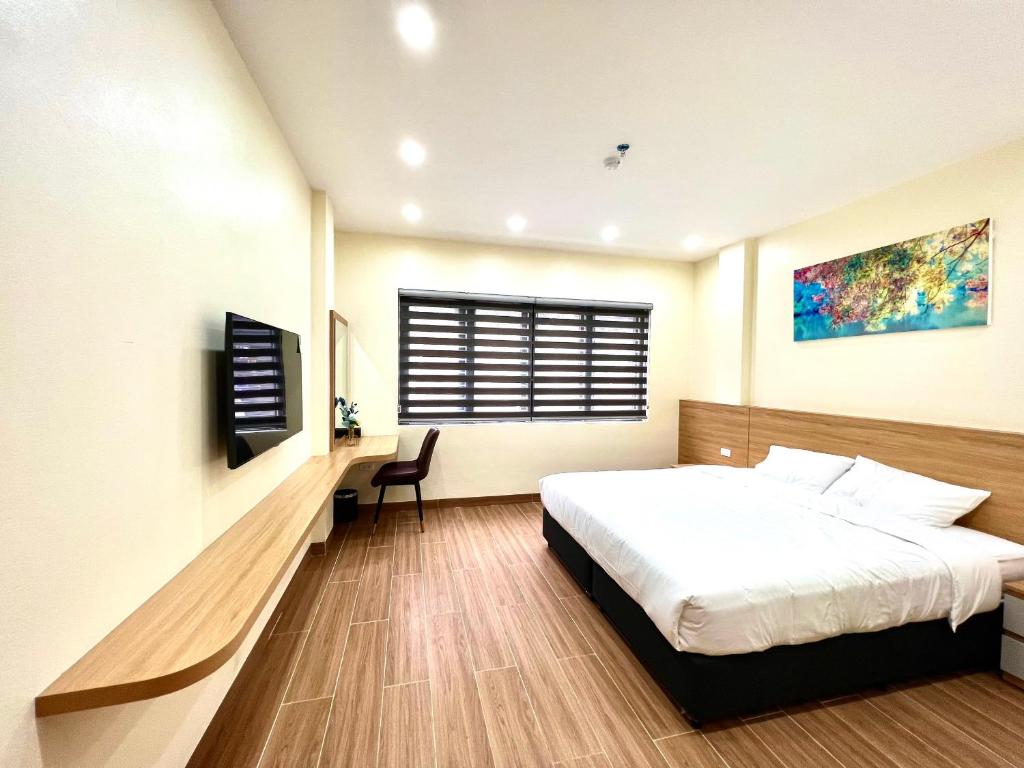 a bedroom with a bed and a desk and a window at Orion Hotel Halong in Ha Long