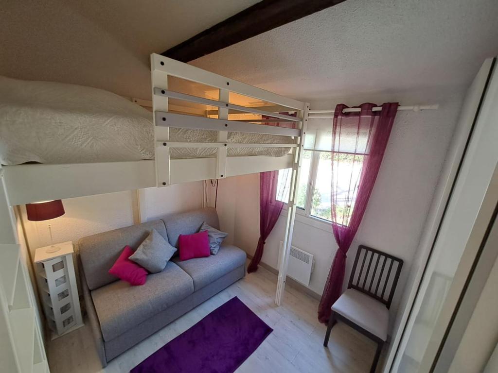 a small room with a bunk bed and a couch at T3 Le Bagnolet Les Mas de Pramousquier in Le Lavandou