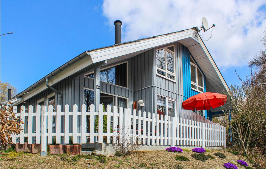 a house with a white fence and a red umbrella at 3 Bedroom Cozy Home In Extertal in Extertal