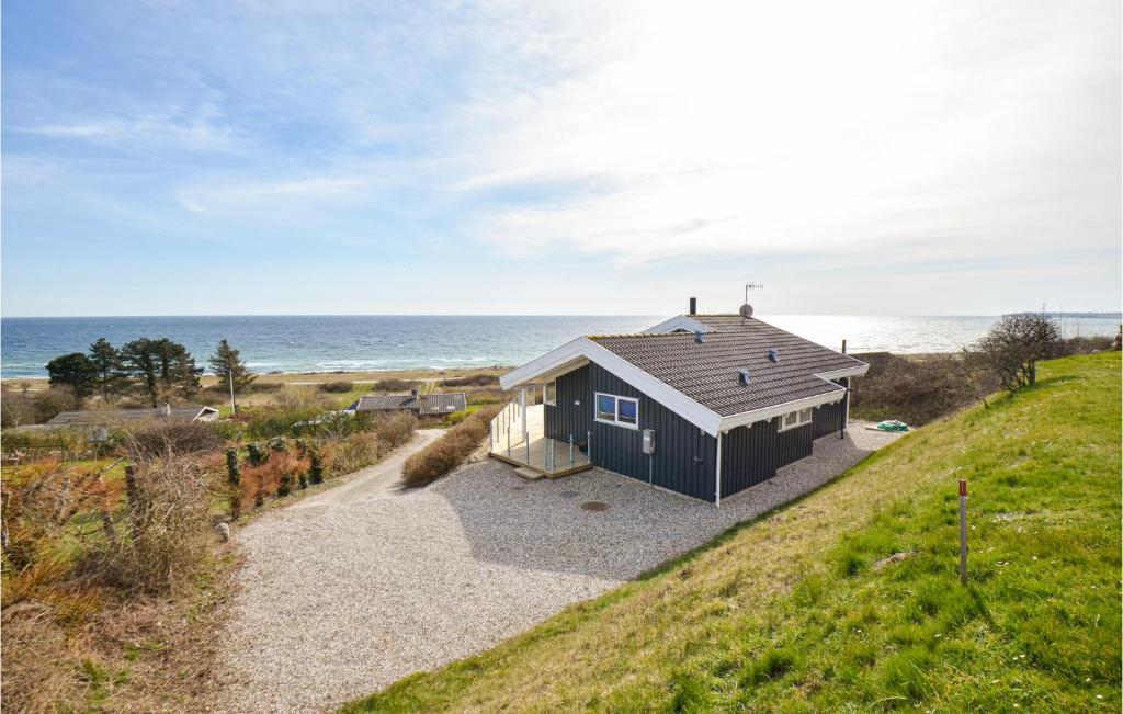 a black house on a hill next to the ocean at Beautiful Home In Ebeltoft With Wifi in Ebeltoft