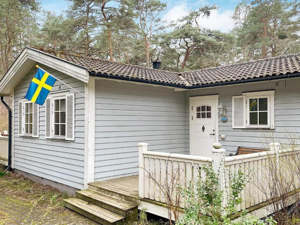 a small house with a flag on the side of it at Holiday home YNGSJÖ III in Yngsjö