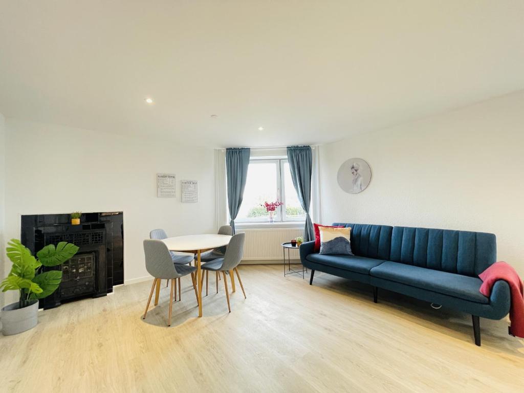 a living room with a blue couch and a table at aday - Blue Sea apartment with balcony in Frederikshavn