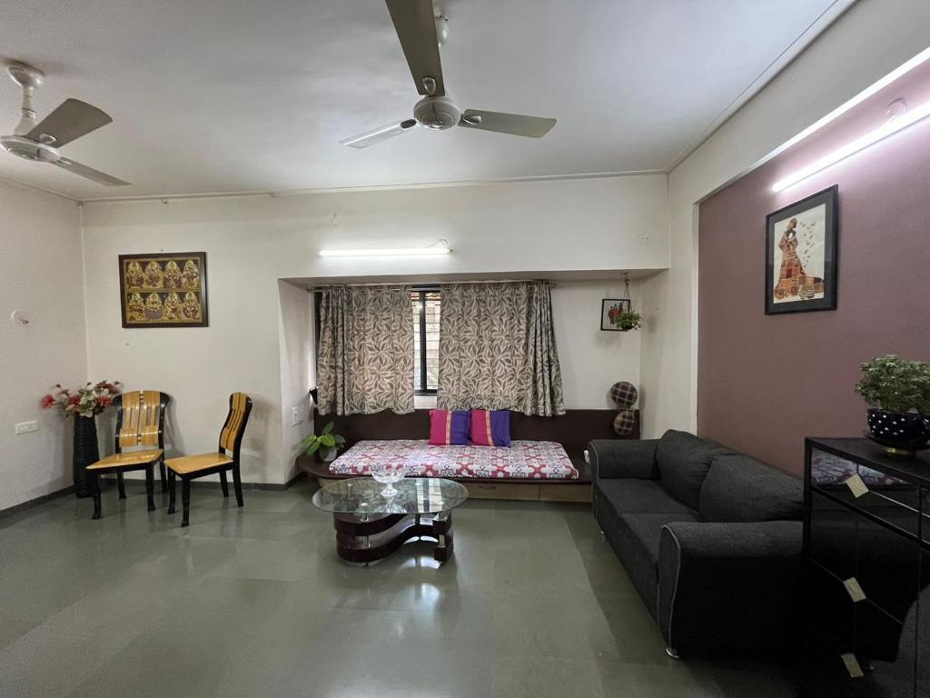 a living room with a couch and a bed at Tripvana Apartment in Nashik