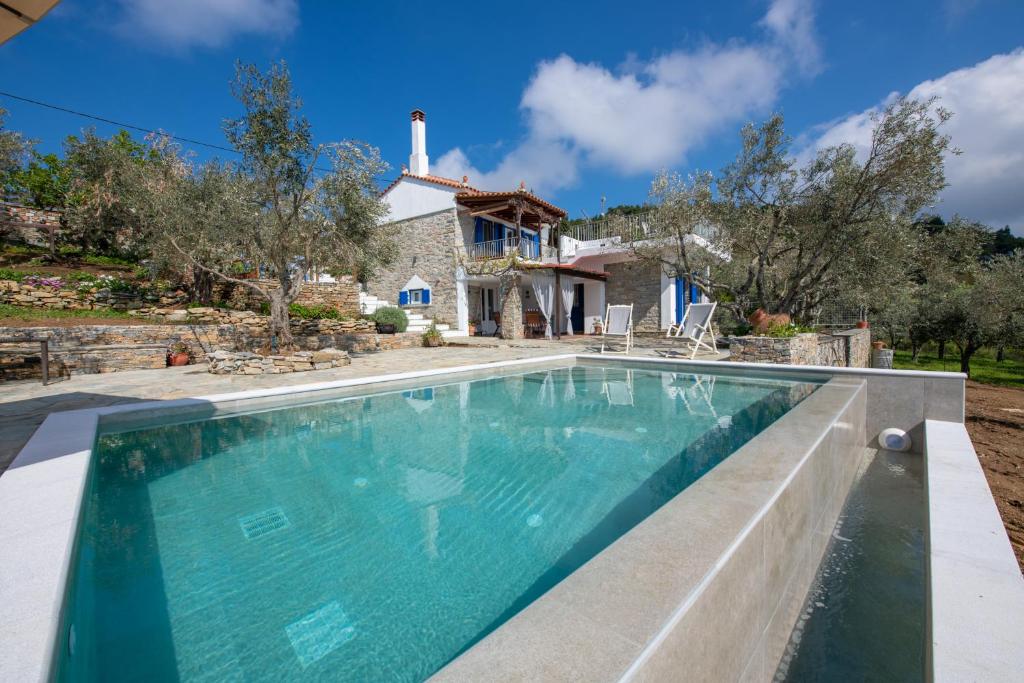 una imagen de una piscina frente a una casa en Villa Marouda, en Glossa