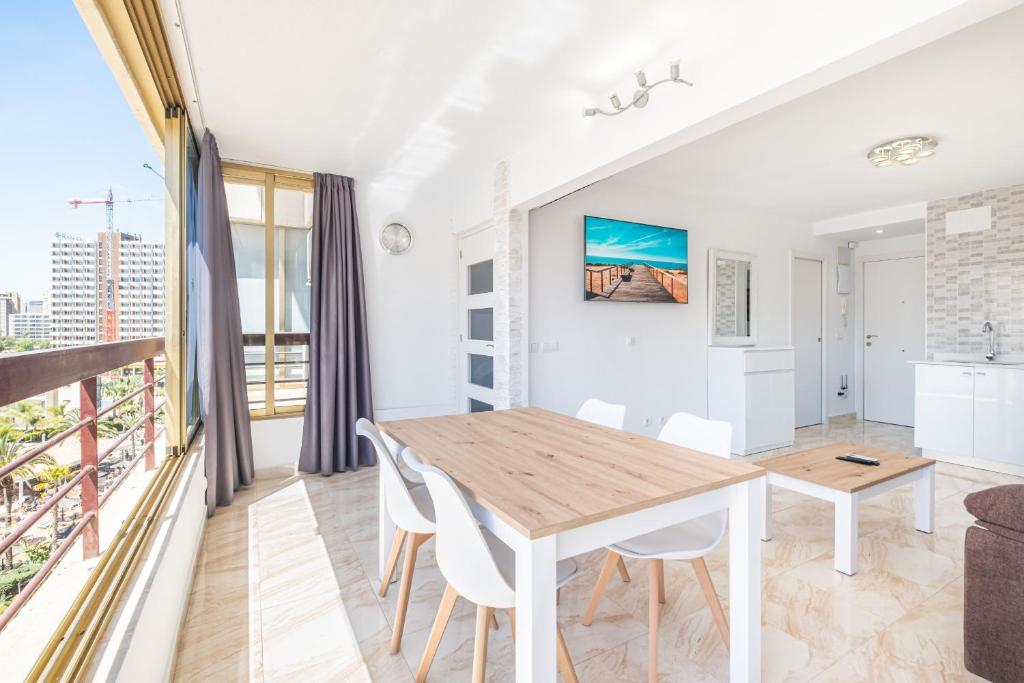 kuchnia i salon z drewnianym stołem i krzesłami w obiekcie Acuarium II 5-B Apartment Levante Beach w mieście Benidorm