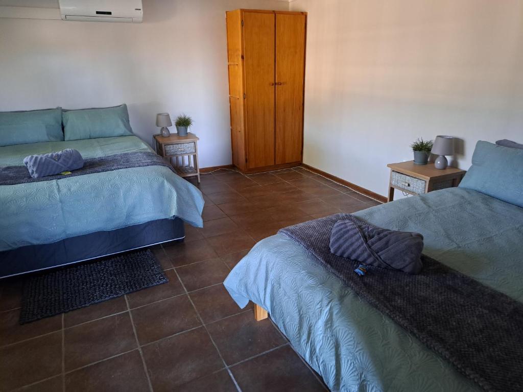 una camera con 2 letti e un pavimento piastrellato di Ansa Guesthouse ad Augrabies