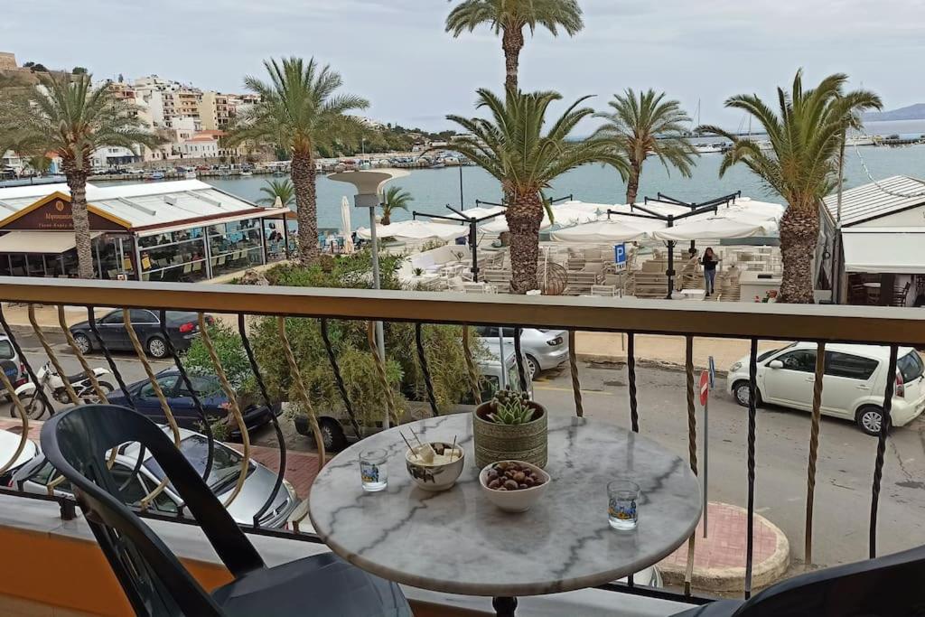 a table on a balcony with a view of a marina at SeaShell apartment Sea View, Castle View 200metres from the Beach in Sitia