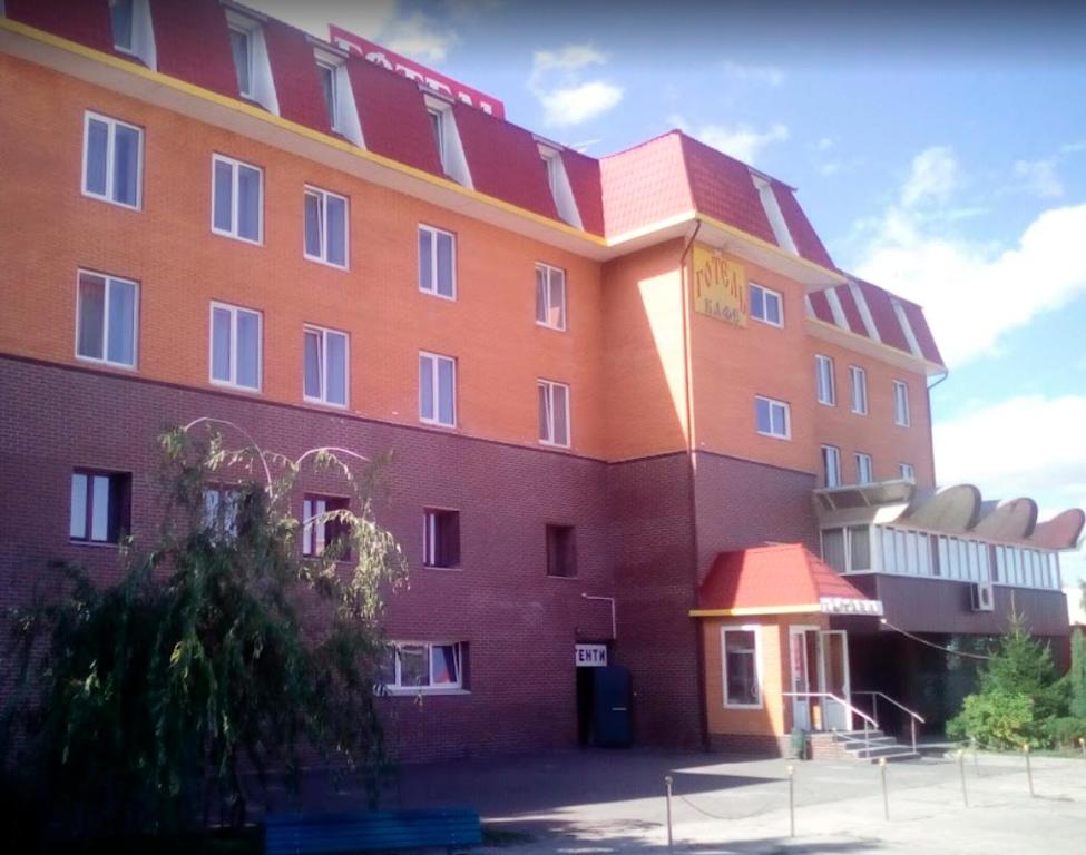 ein großes rotes Gebäude mit Balkon in der Unterkunft Тиса Економ in Kiew