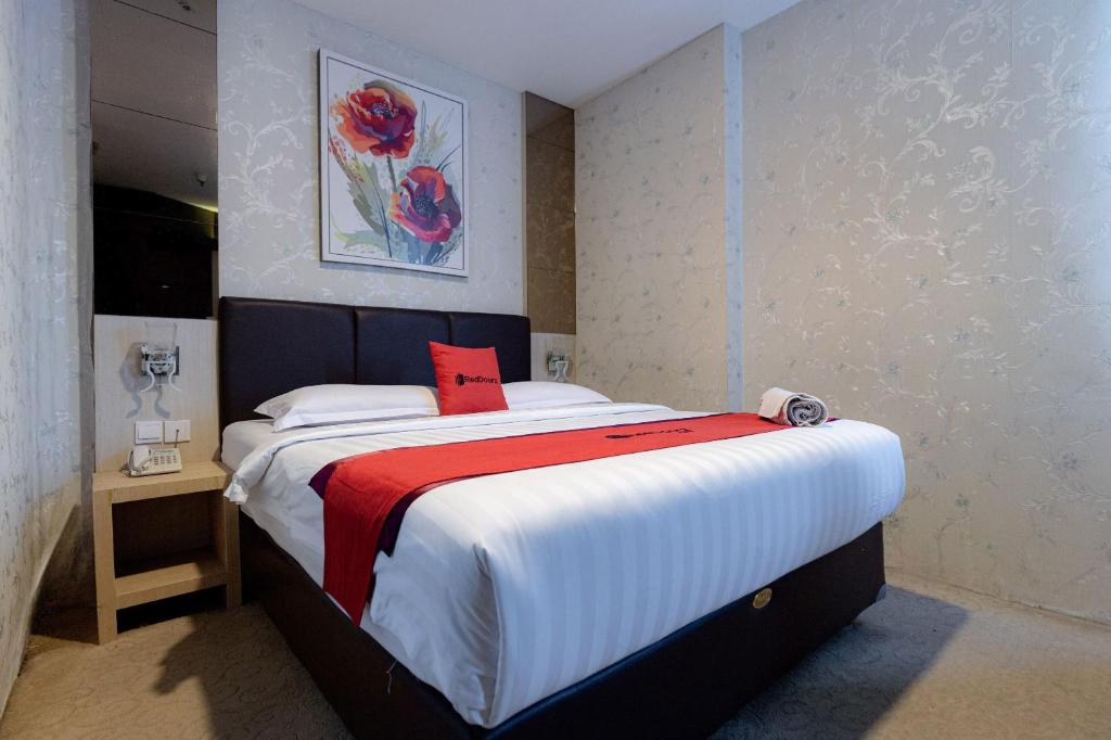 um quarto com uma cama grande e um cobertor vermelho em RedDoorz Premium near Grand Batam Mall em Nagoya
