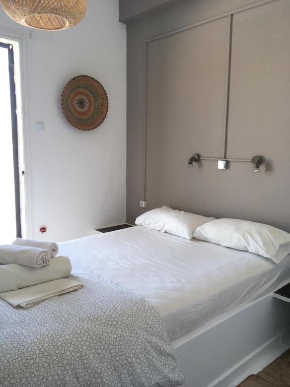 a white bed with two pillows on top of it at Cristi Rooms in Livadi
