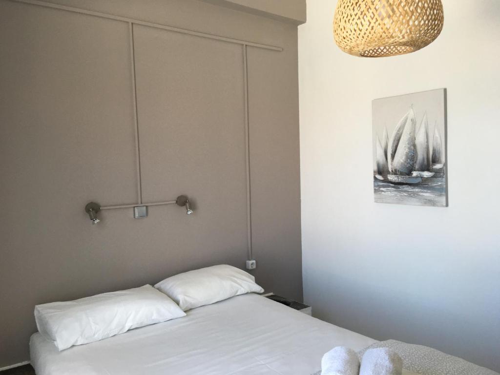 a bedroom with a bed and a chandelier at Cristi Rooms in Livadi