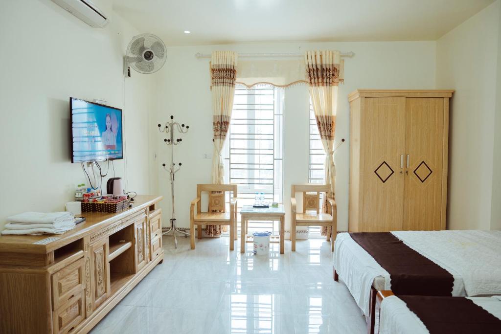 a bedroom with a bed and a desk and a television at Hoan Hao Hotel in Ha Giang