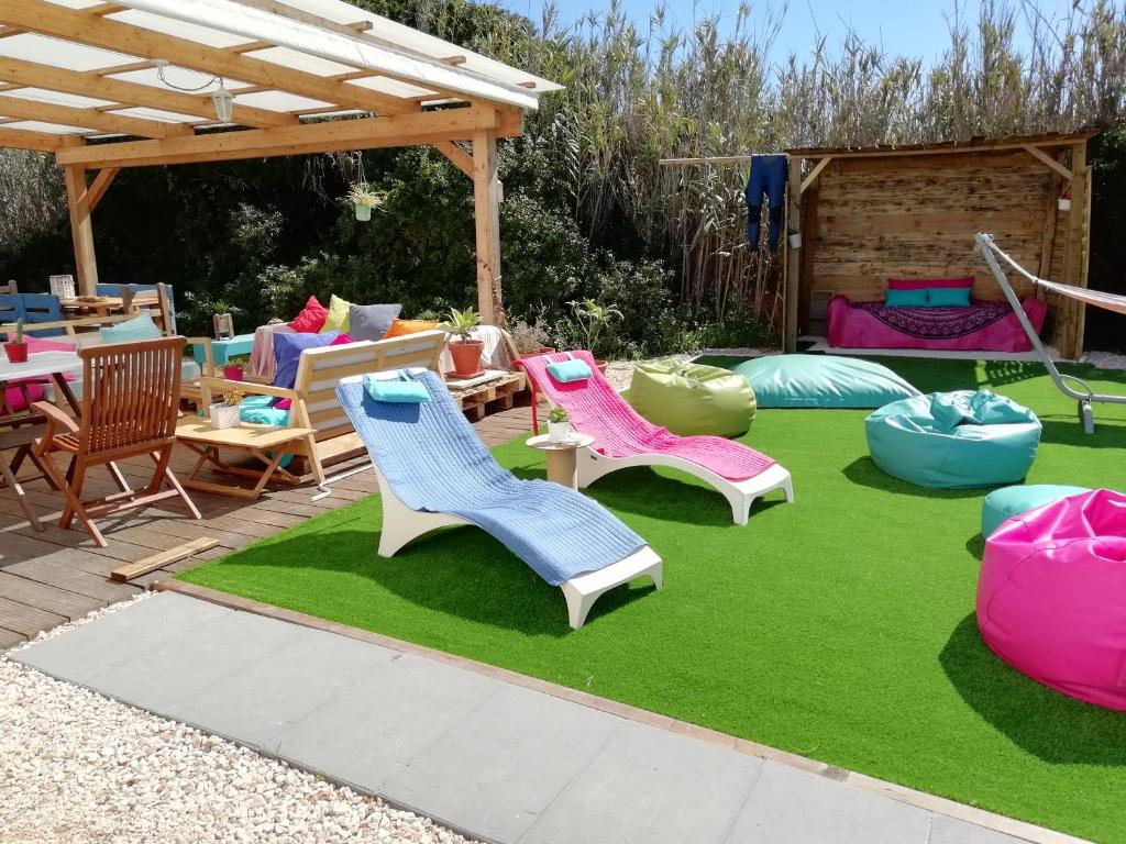 a yard with chairs and tables on a lawn at Blacksheep Sagres Guesthouse & Surf in Sagres