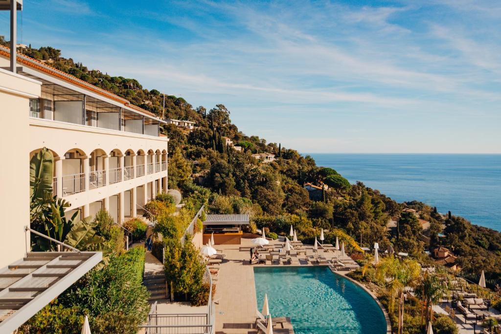 a view of a hotel with a pool and a mountain at Hôtel La Villa Douce in Rayol-Canadel-sur-Mer