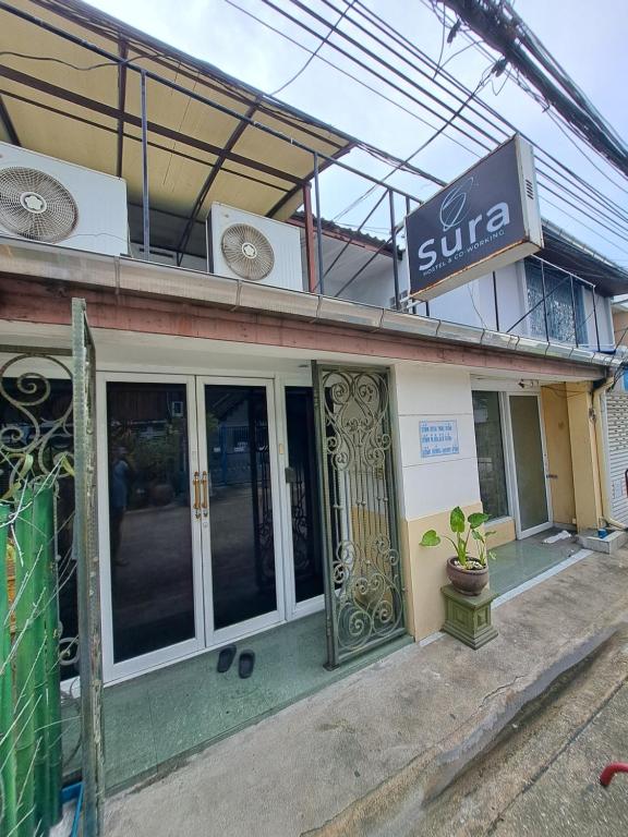 una tienda con puertas de cristal y una señal en ella en Sura Hostel and Coworking en Bangkok