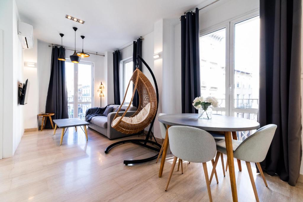 un soggiorno con tavolo, sedie e divano di Precioso Apartamento en el Centro de Granada. a Granada