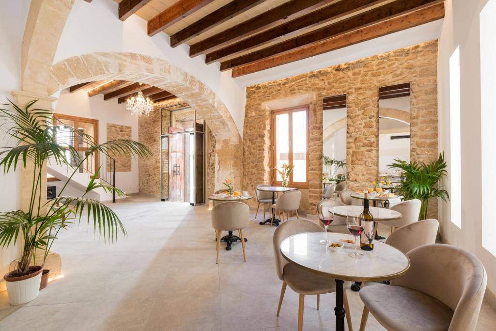 阿爾庫迪亞的住宿－Petit Palau Alcudia - Adults Only，一间带桌椅的餐厅以及砖墙