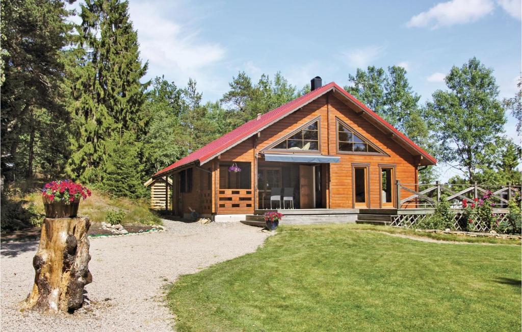 a log cabin with a tree stump in front of it at 3 Bedroom Stunning Home In Färgelanda in Muberg