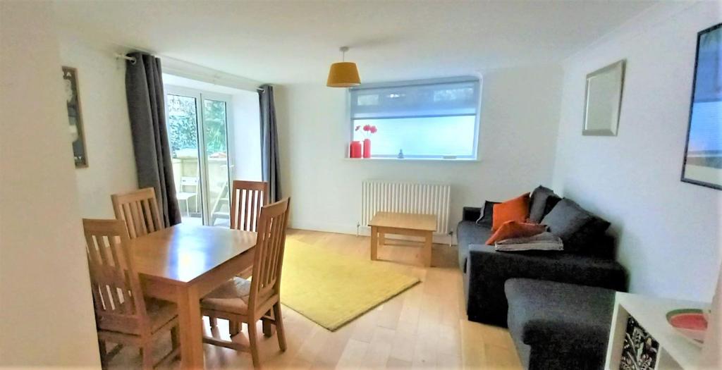 a living room with a table and a couch at 2 Bedroom Victorian Garden Flat in London