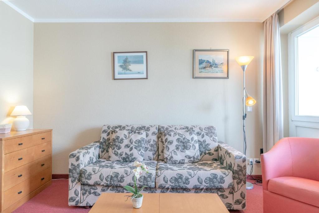 uma sala de estar com um sofá e uma cadeira em Seepark Sellin Fewo AG Whg 255 em Ostseebad Sellin