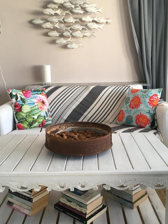 a white couch with a bowl on top of books at Cristi Rooms in Livadi