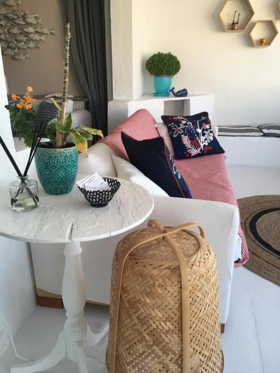 a living room with a white couch and a table at Cristi Rooms in Livadi