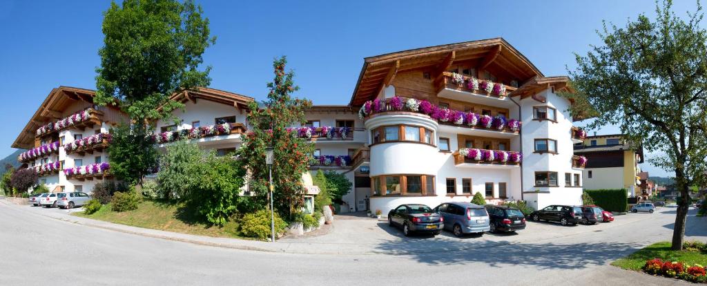 um grande edifício com carros estacionados em frente em Ferienhotel Fuchs em Söll