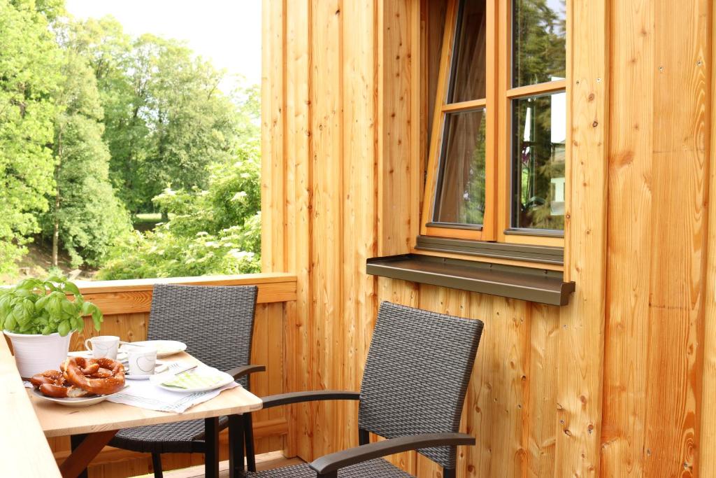una mesa y sillas en un porche con ventana en Ferienwohnung Jaud - Gmund am Tegernsee en Gmund am Tegernsee