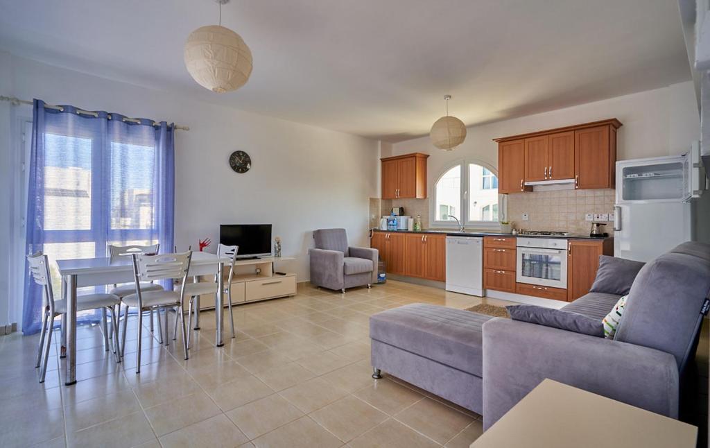 a kitchen and living room with a table and a couch at Aphrodite Apartments North Cyprus in Ghaziveran