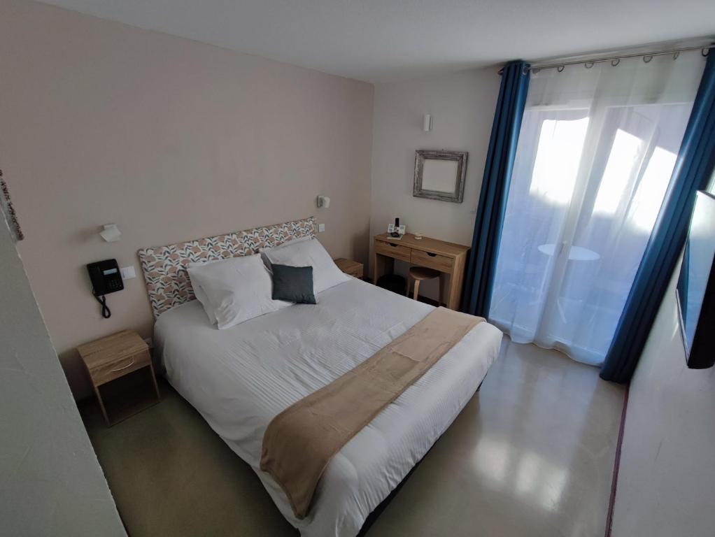 Postel nebo postele na pokoji v ubytování Logis Hotel De La Clape