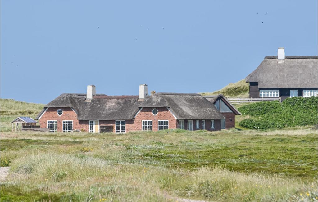 un grupo de casas en un campo con hierba en Stunning Home In Ringkbing With House A Panoramic View, en Ringkøbing