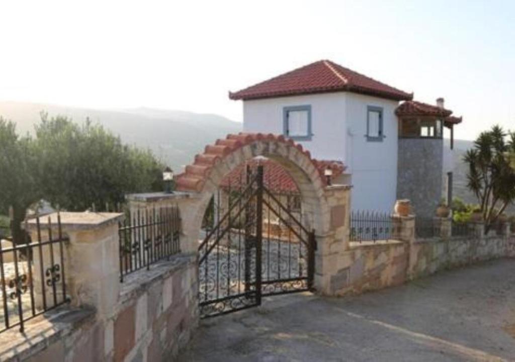 a fence with a gate in front of a building at Cretan Country house in Áyios Spirídhon