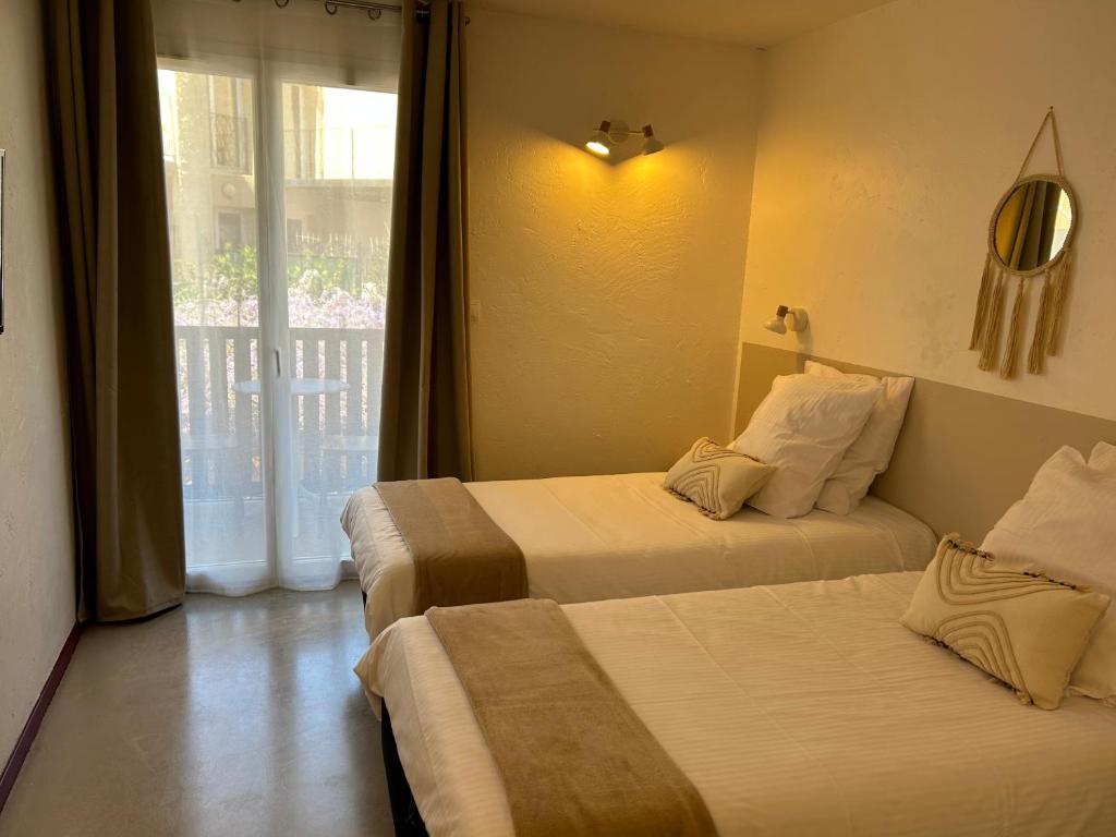 Postel nebo postele na pokoji v ubytování Logis Hotel De La Clape
