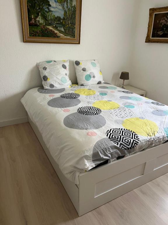 een slaapkamer met een bed met een wit bedframe bij Villa Jean in Blankenberge