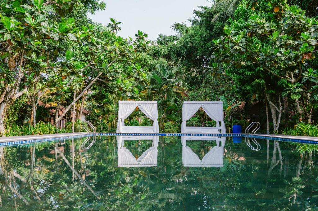 a pool at the resort with trees in the background at An Nhien Retreat in Phu Quoc