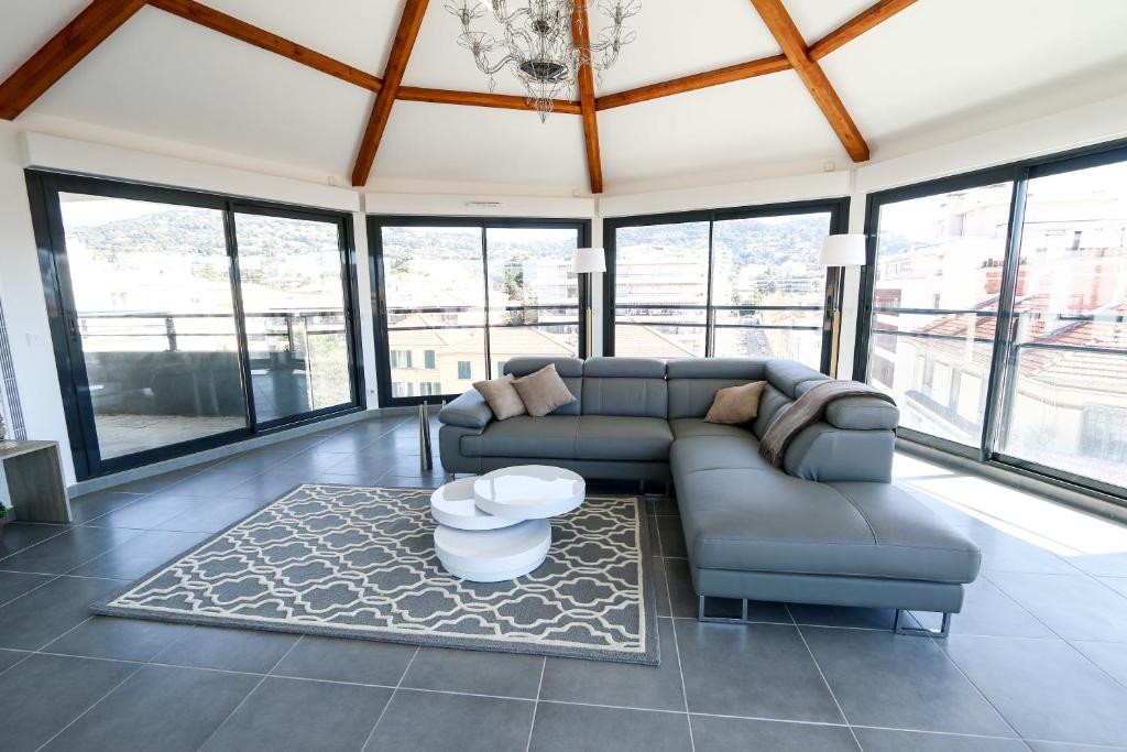 a living room with a couch and some windows at Unique a Cannes in Cannes