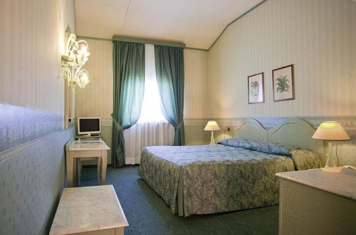 um quarto de hotel com uma cama e uma janela em Hotel Bentivoglio Residenza D'Epoca em Bentivoglio