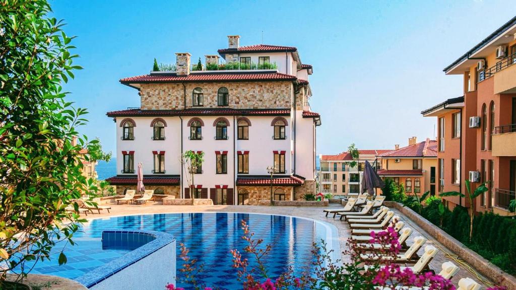 un bâtiment avec une piscine en face d'un bâtiment dans l'établissement Luxury Apartments Artur, à Sveti Vlas