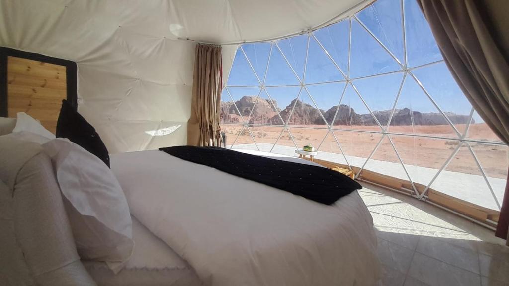 um quarto com uma cama e vista para o deserto em Wadi Rum Camp em Wadi Rum