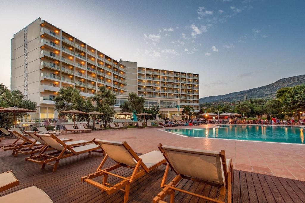 a hotel with chairs and a swimming pool at Evia Riviera Resort in Amarinthos