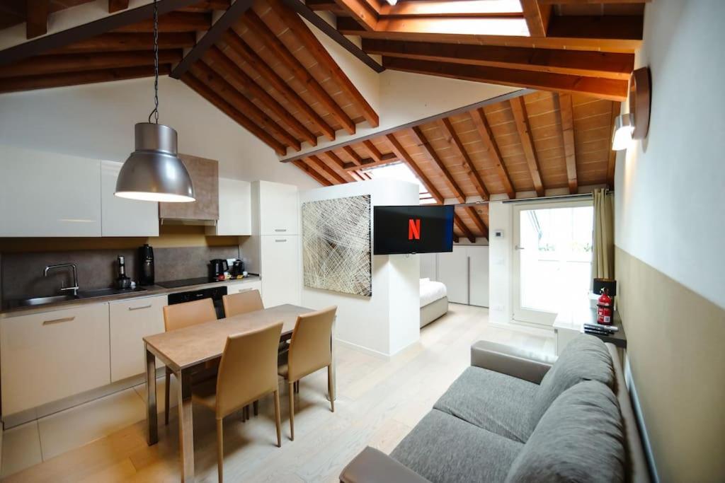 a kitchen and a living room with a couch and a table at [DUOMO] Elegant Penthouse in Parma