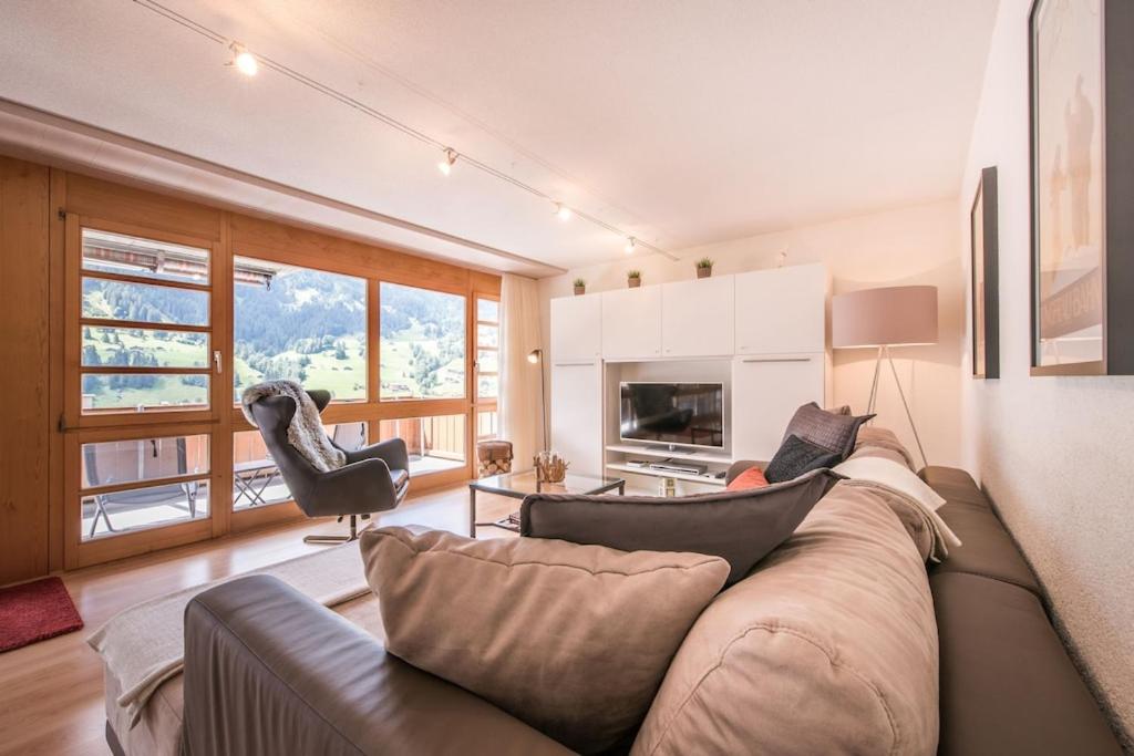 uma sala de estar com um sofá e uma mesa em Breithorn Apartment, Eiger North Face View em Grindelwald