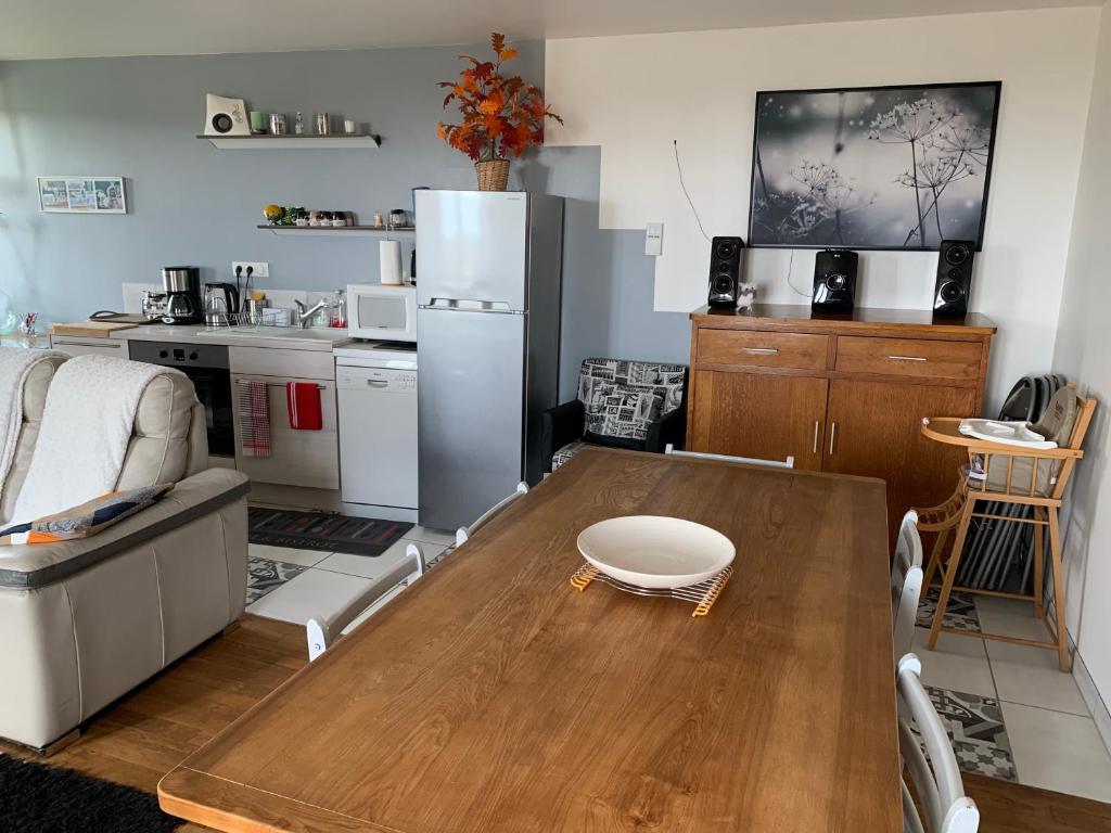 cocina con mesa de madera y nevera en Fontanies en Aubrac en Laguiole