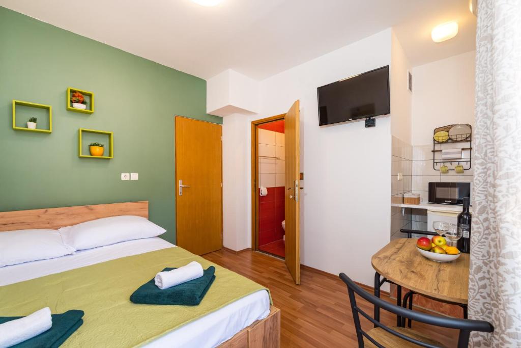 a hotel room with a bed and a table with a tableablish at Studio and Rooms Zadar City Wall in Zadar