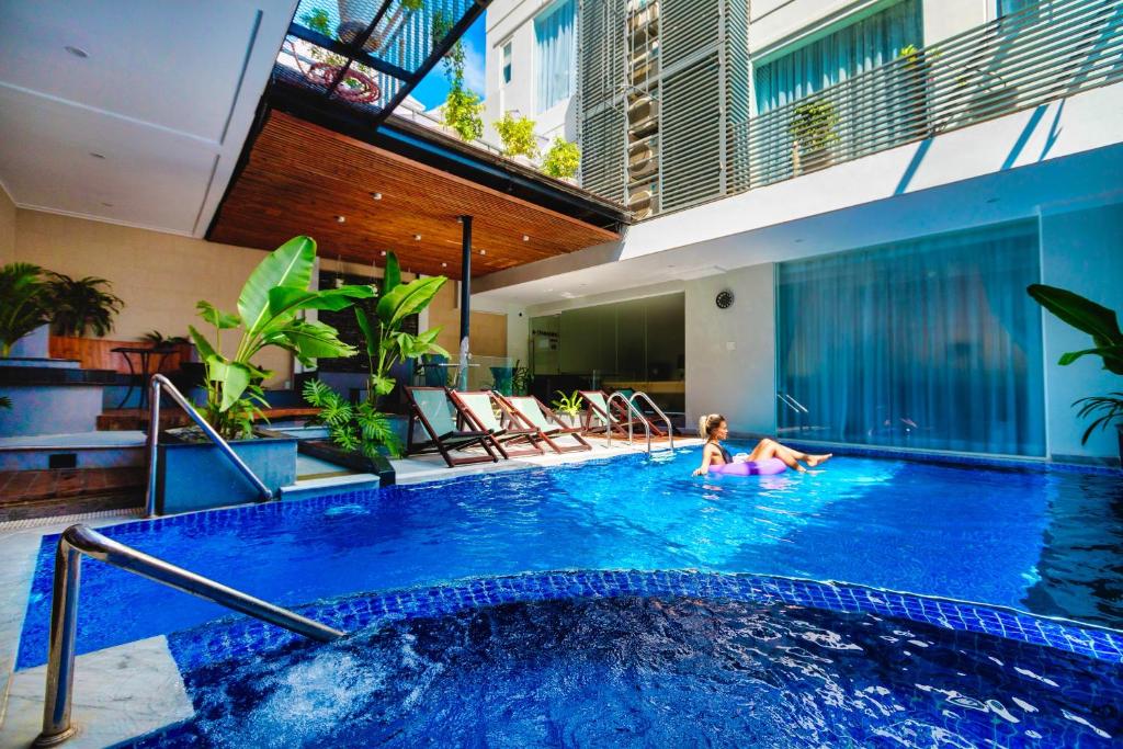 a woman in a swimming pool in a hotel at The Wind Mountainside Hotel in Vung Tau