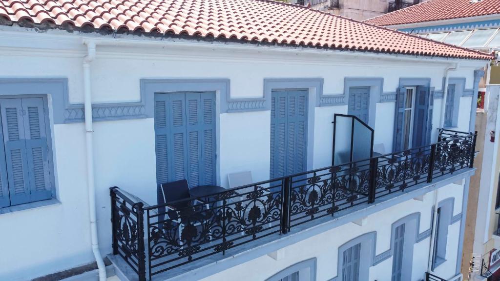 - un balcon dans un bâtiment blanc avec volets bleus dans l&#39;établissement Leonidas Hotel, à Gythio