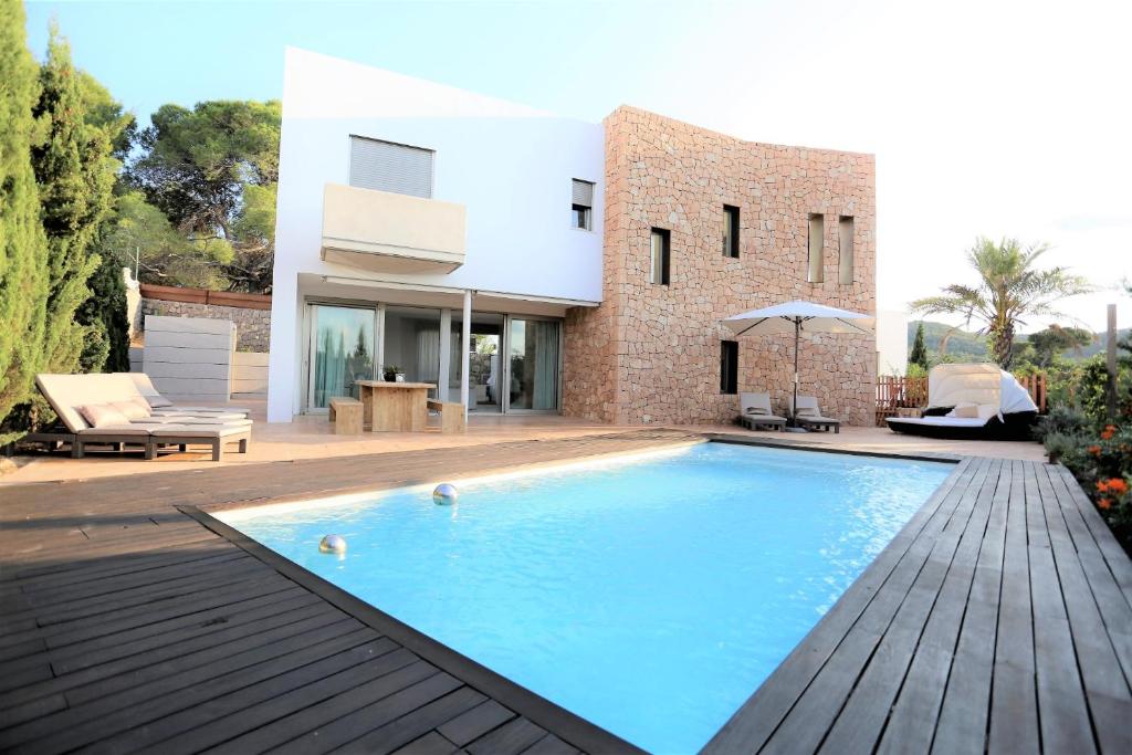 a swimming pool in front of a house at Modern Villa Montecristo in Montecristo